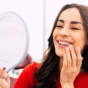 Woman admiring her reflection in a handheld mirror
