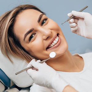 Woman in dental chair smiling about to have dental exam