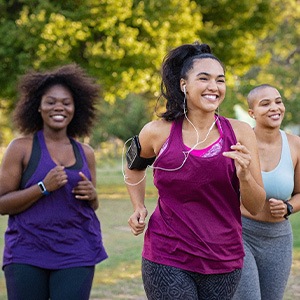 Group of women smiling while jogging in park