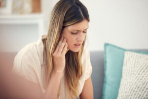 Woman holding mouth in pain.