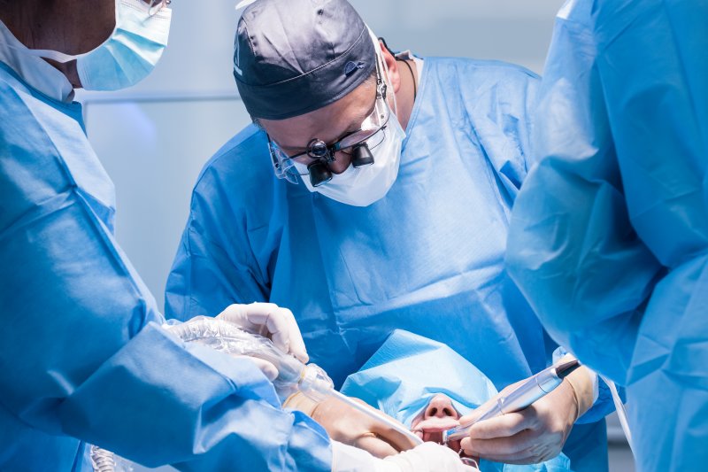 Oral surgeons performing a dental implant surgery